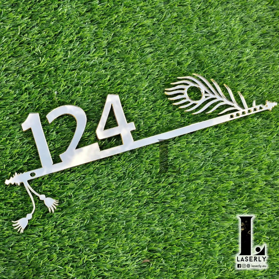 Elegant Krishna-themed house number plaque with decorative flute detailing on exterior wall.