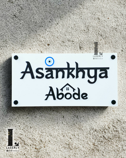 Acrylic house name sign in black and white featuring an evil eye motif, mounted on front wall.