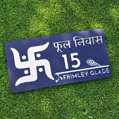 Modern black acrylic house number sign with mirror gold Swastika design mounted beside front door.