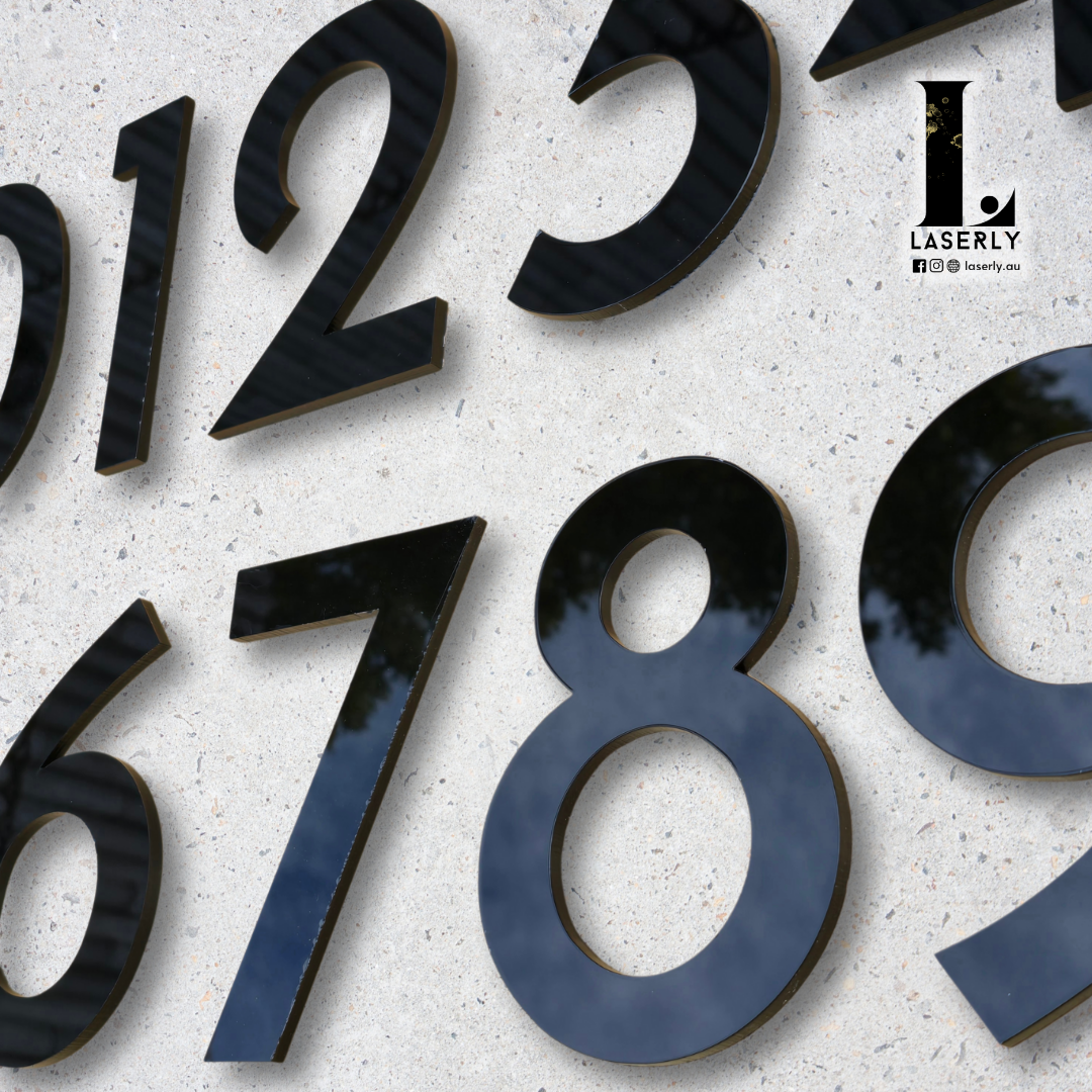 Black and white house number sign mounted beside a modern home entrance.
