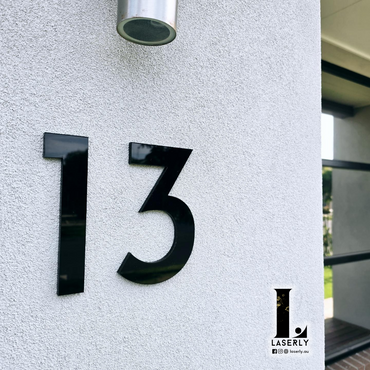Front door view featuring a stylish black and white house number sign.