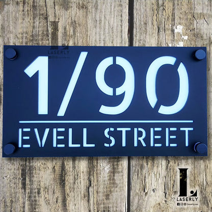 Minimalist acrylic house number plaque fixed near the main entryway.