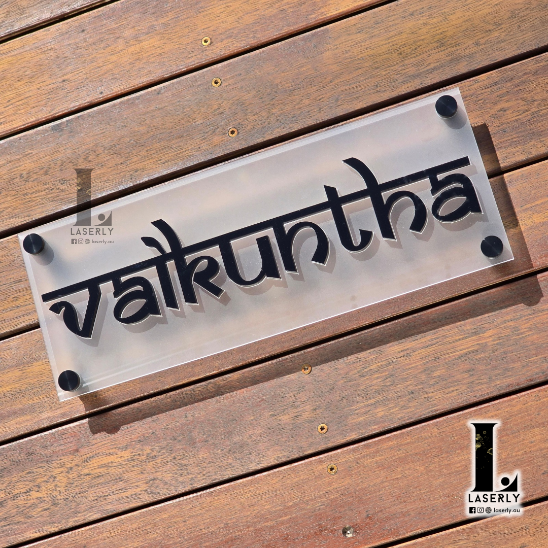 Elegant house name sign mounted beside the front door on a modern exterior wall.