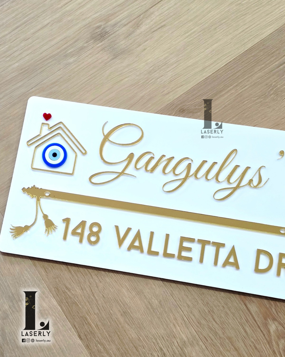 Modern white house number plaque with flute design and blue evil eye accent for home entrance.