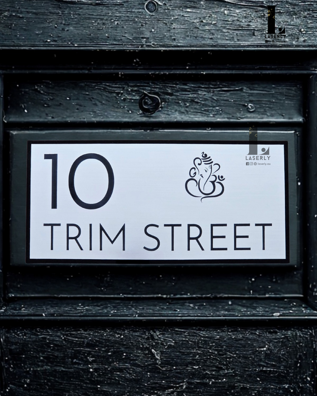 Modern minimalistic house number sign featuring Lord Ganesha design, mounted on exterior wall.