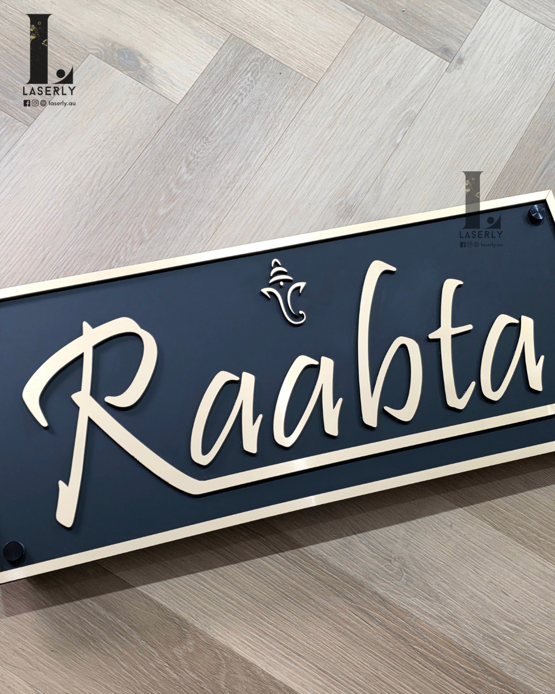 Elegant gold layered Ganesha design on matte black acrylic house number plaque for home entrance.