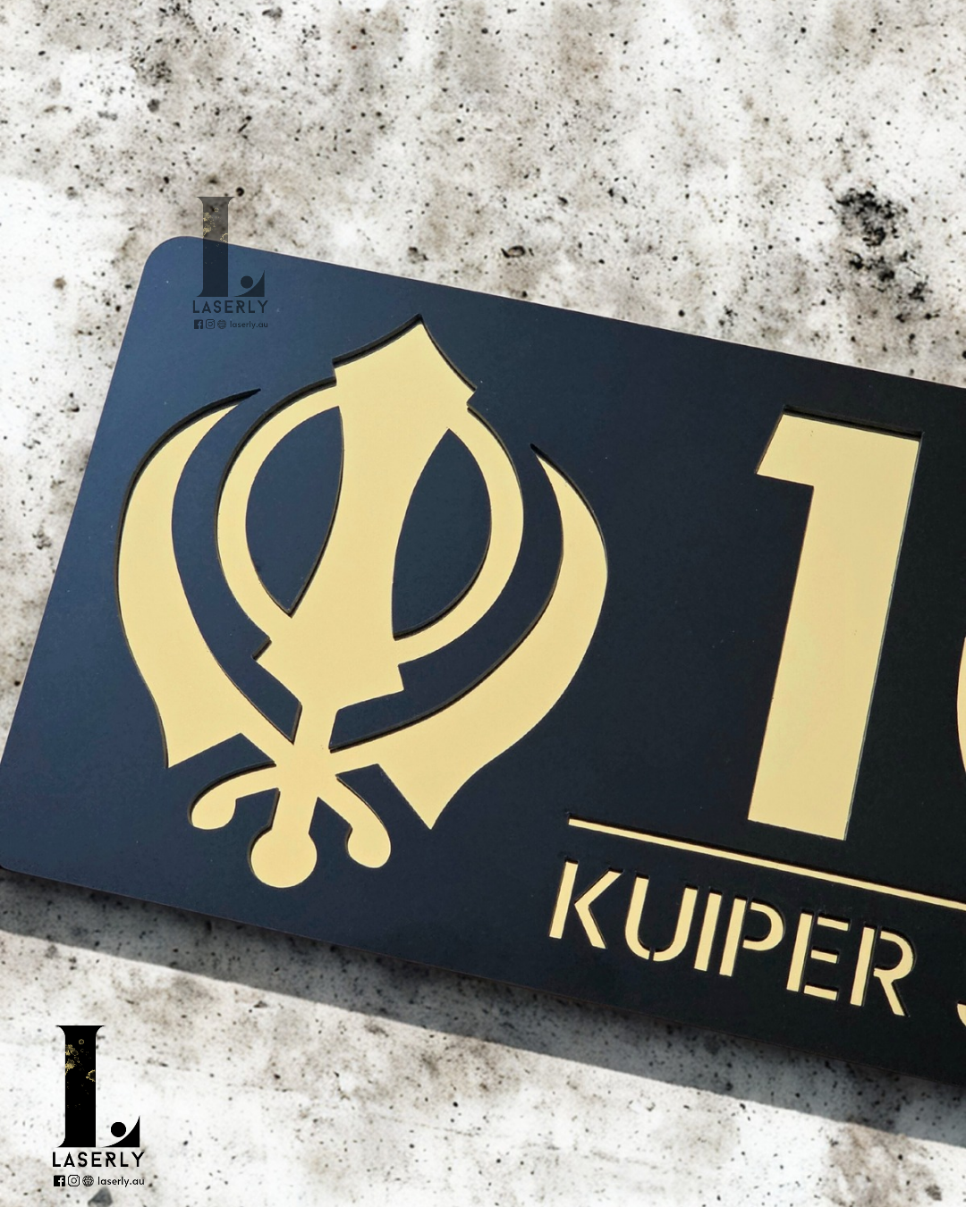 Black and metallic gold Kandha house number plaque displayed beside front door.