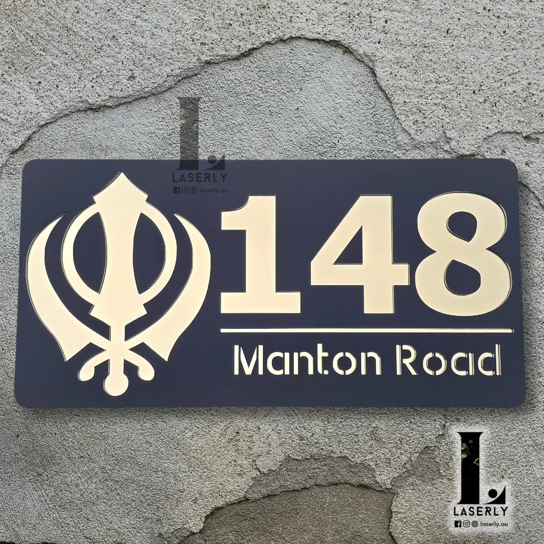 Elegant Kandha house number plate in black and metallic gold finish for home entrance.