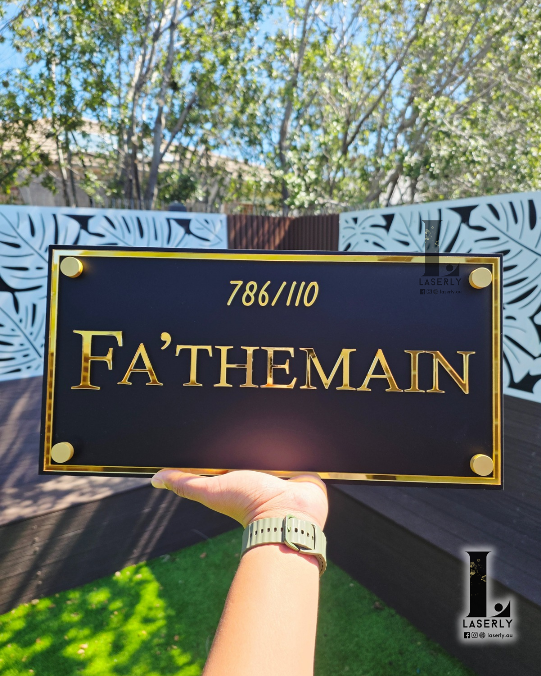 Minimal style house name sign in black acrylic mounted on light-coloured wall.