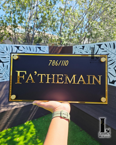 Minimal style house name sign in black acrylic mounted on light-coloured wall.
