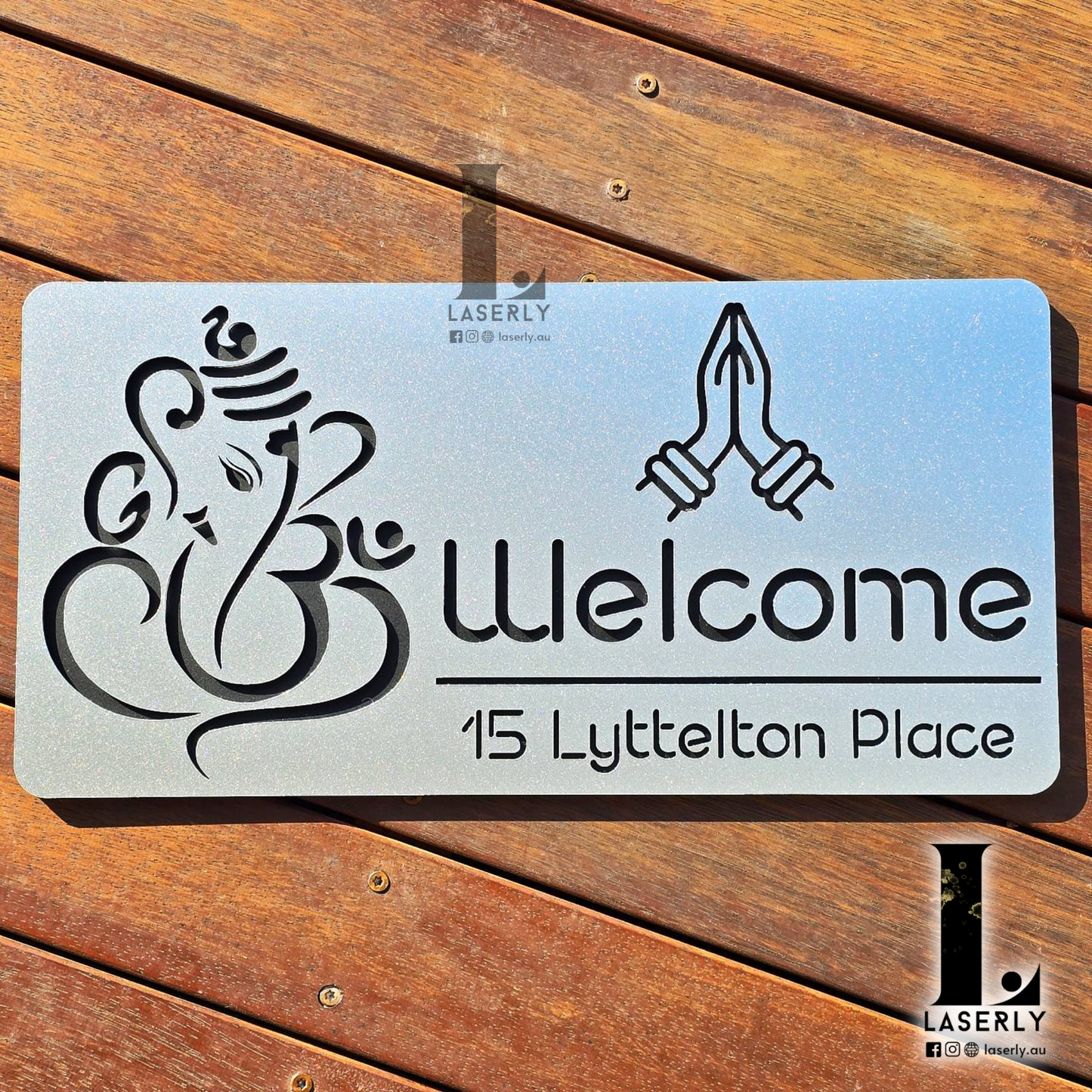 Front view of steel-look acrylic Ganesha house number sign mounted on a home exterior wall.