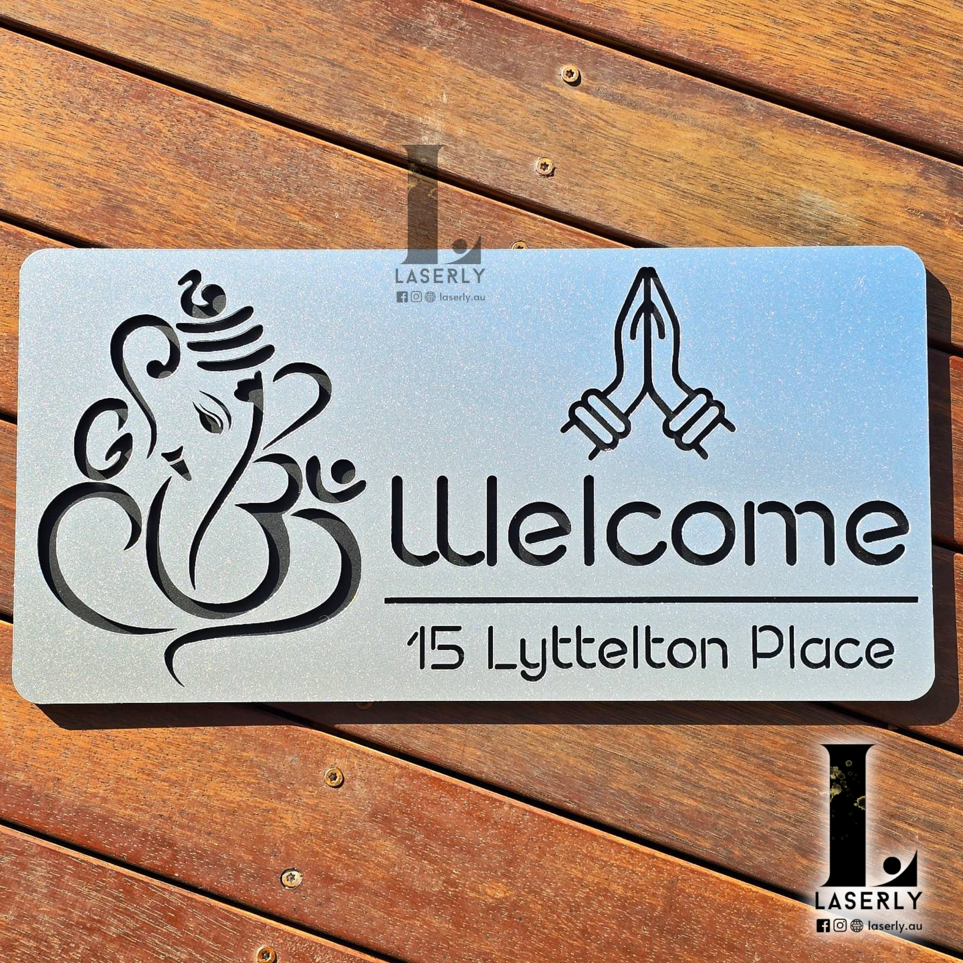 Front view of steel-look acrylic Ganesha house number sign mounted on a home exterior wall.