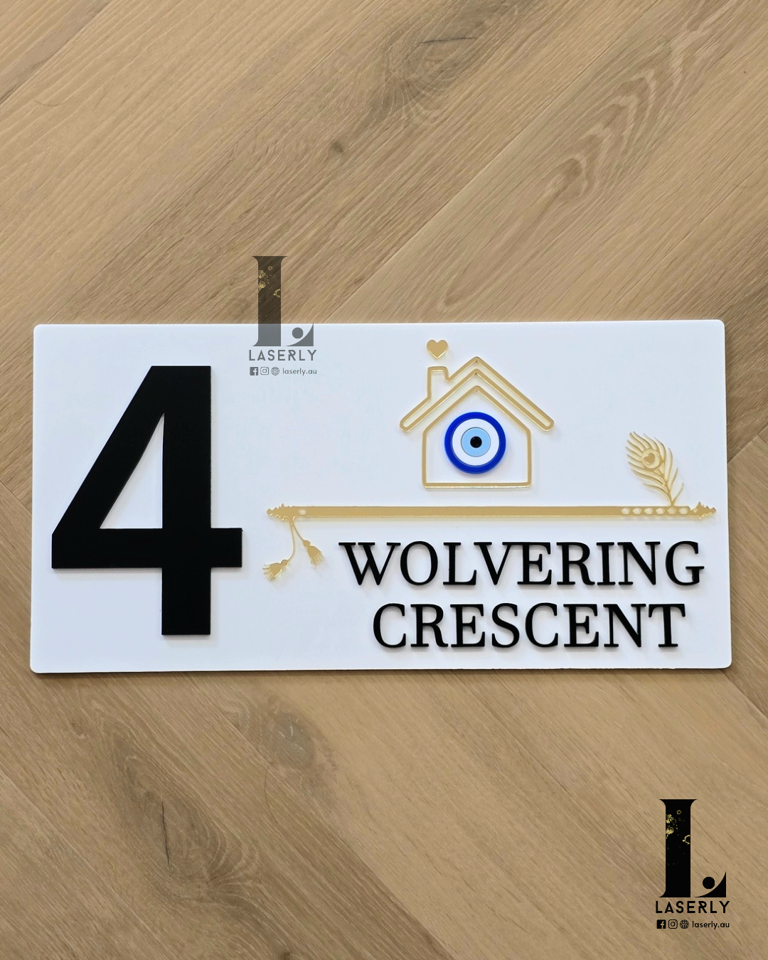 White flute house number sign mounted on exterior wall with decorative evil eye.