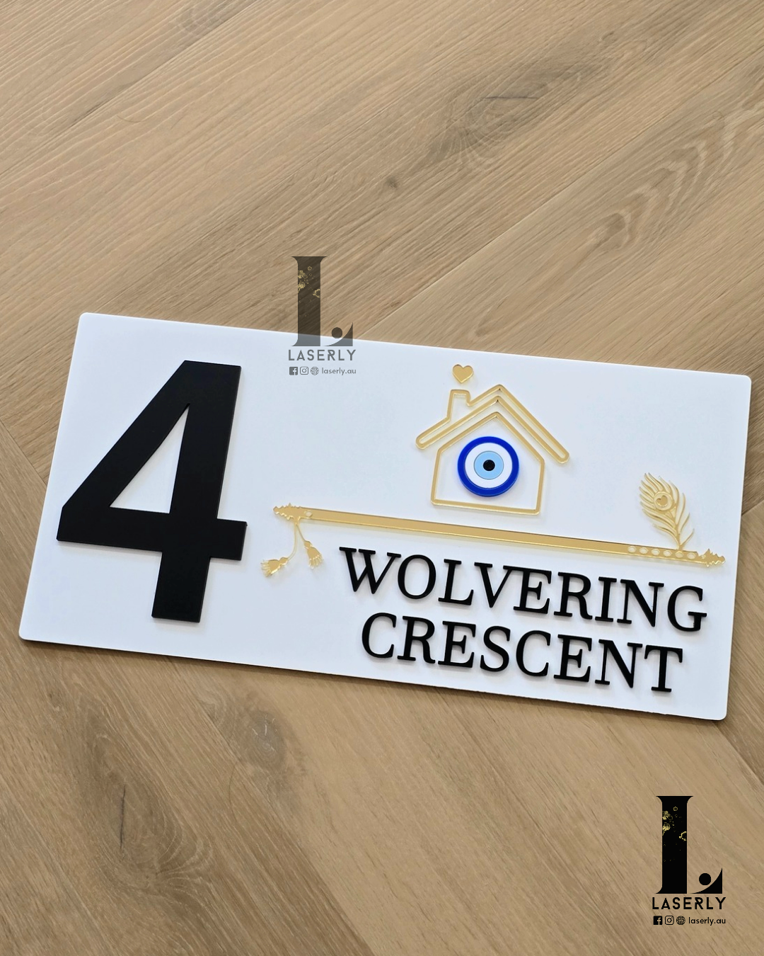 White exterior house number sign decorated with symbolic evil eye.